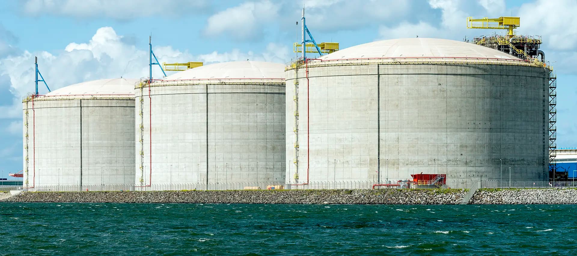 A view of large tanks in a harbor used in the liquefied natural gas industry.