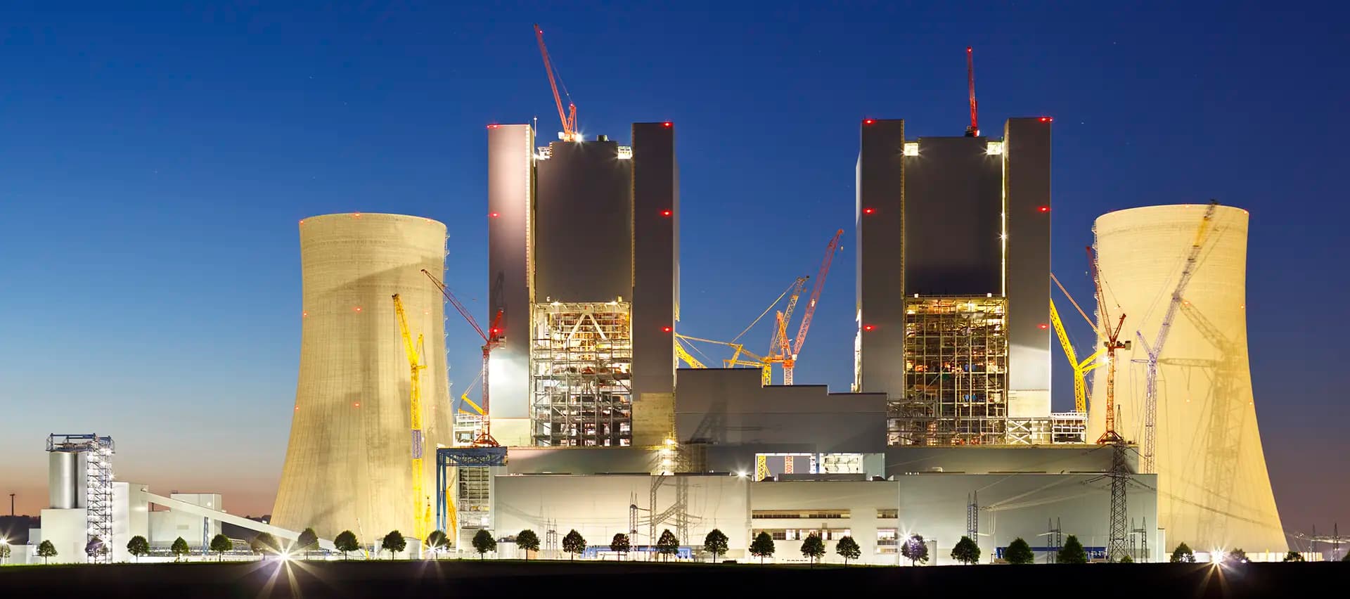 A nuclear power plant at night. The lights are on and the plant is operational, showing the importance of keeping these plants running efficiently and safely.