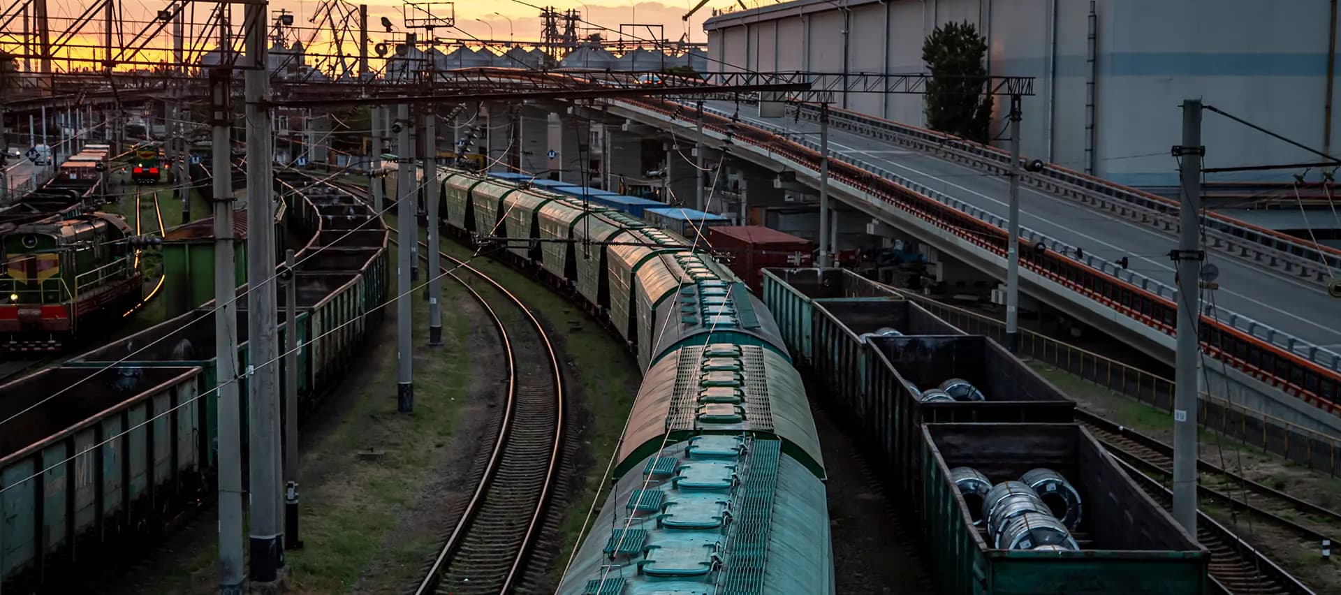 An elevated view of a rail system, with many traincars and tracks visible. The image shows the scale of the rail industry and the need for reliable maintenance solutions.