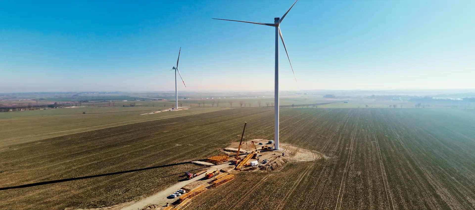 A wind turbine under active construction or maintenance in a field.