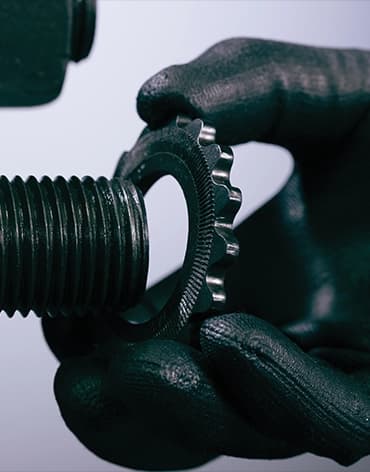 A person installing the TRUE-LOCK Reaction Washer, a washer with a dual-face locking mechanism that prevents pinch points and loosening from vibration.