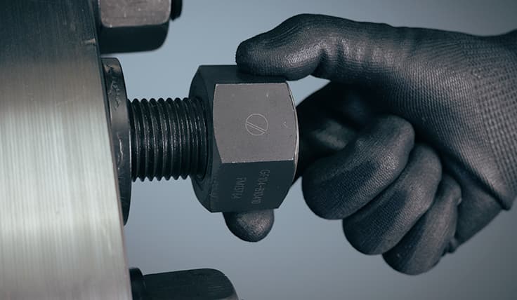 A gloved hand threads the Gall-Free Nut onto an application.
