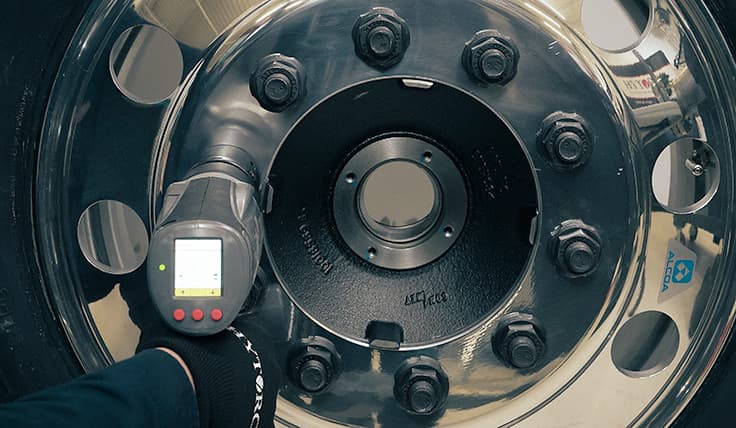 A straight-on view of a LION GUN Electric Torque Tool bolting a GRIP-TIGHT™ Nut onto a wheel application.
