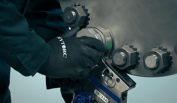 A technician attaching the Tool Retainer to the STEALTH Hydraulic Torque Wrench, allowing it to stay fixed on an application without being held.