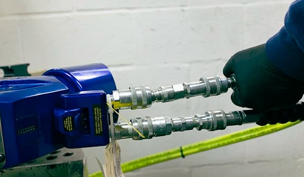 A technician inspecting a hose connector on an MXT+ Hydraulic Torque Wrench