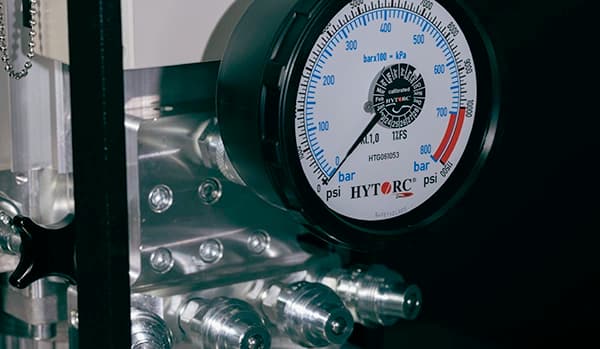 An analog pump gauge showing possible pressure values for a hydraulic system.
